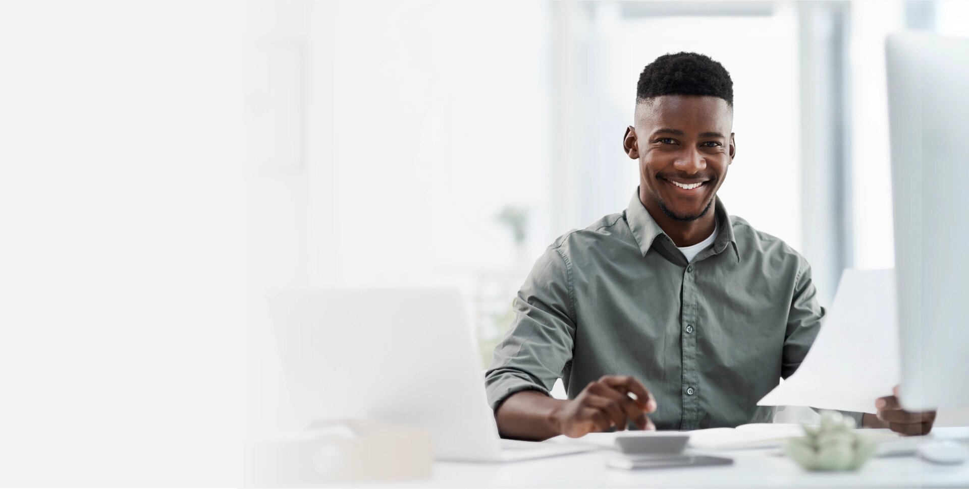Homem sorrindo enquanto organiza as finanças no computador